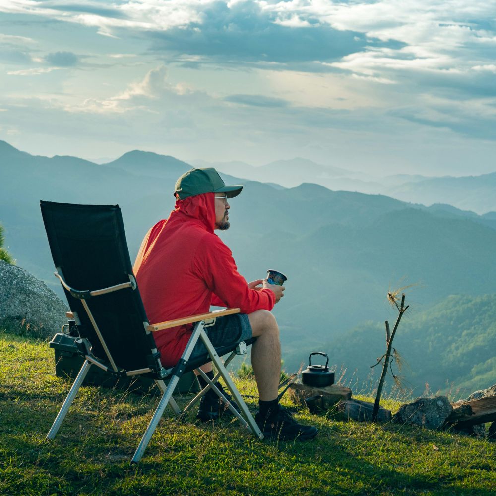 Person sitting in a chair with a scenic mountain view